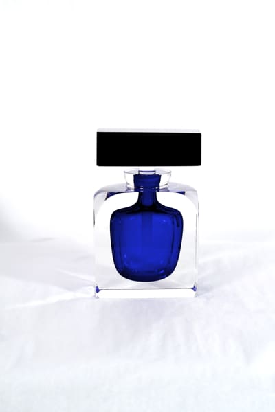 A blue bottle of perfume sitting on top of a table.