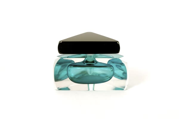 A blue glass container with black lid on top of white surface.