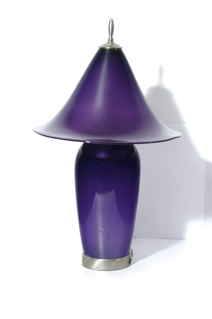 A purple lamp sitting on top of a table.
