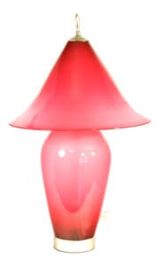 A pink lamp is sitting on the floor.