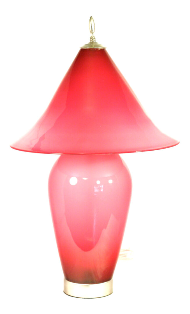 A pink lamp is sitting on the floor.