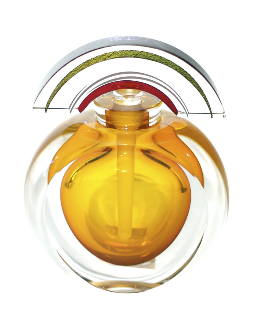 A yellow bottle of perfume in a glass container.