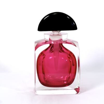 A bottle of pink perfume on top of a table.
